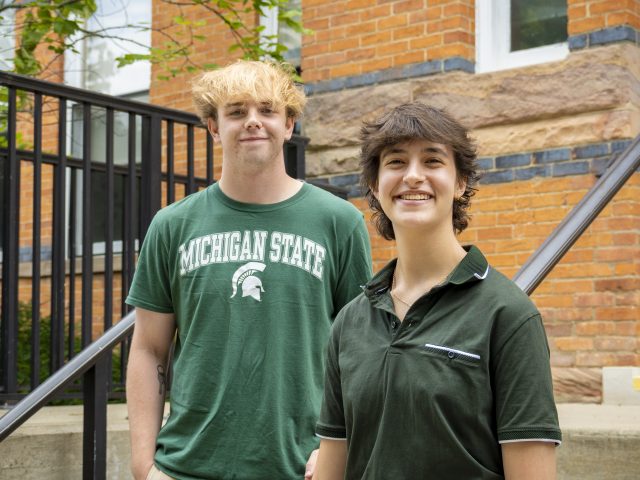 Stephen Lewis and Joanna Gusis outside in front of a brick building