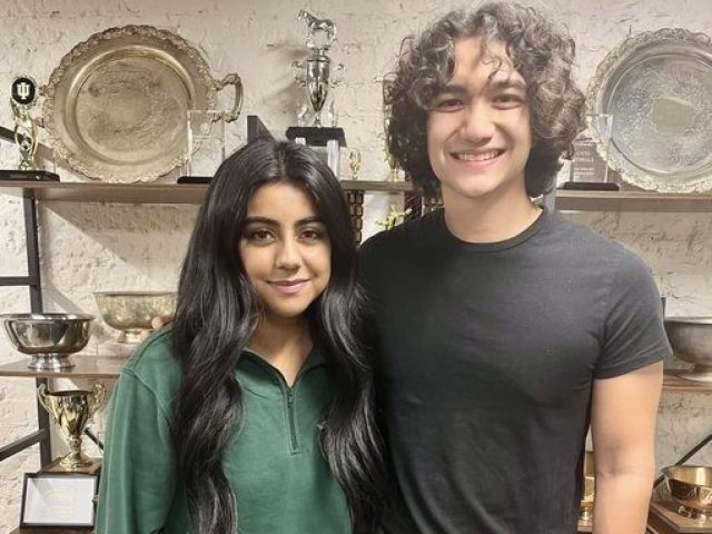 Hina Shehzad and Ephraim Bennett in front of trophies on shelves