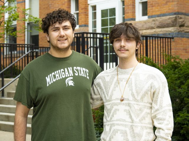 Tony Miklovis and Blaine Montford in front of brick building