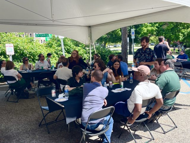 Group sitting outside under tent