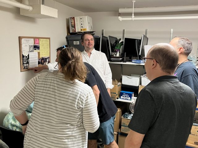 Group gathered looking at something posted on the wall