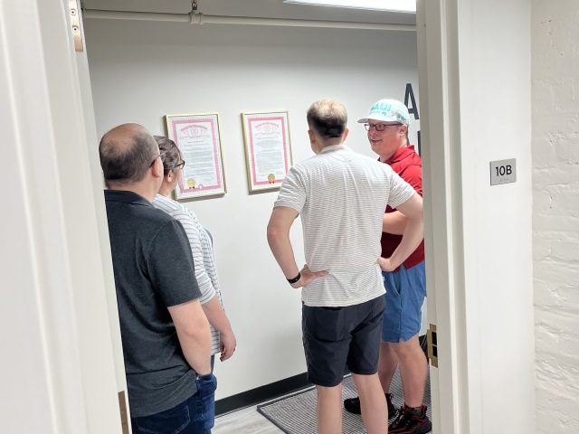 Group gathered looking at something posted on the wall