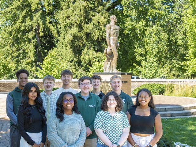 MSU Debate students in front of bronze Sparty statute PC: Sloane Barlow Photography
