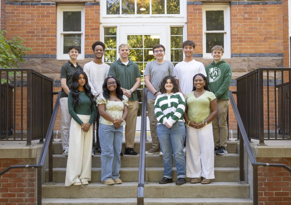MSU Debate Team students on steps in front of brick building PC: Sloane Barlow Photography