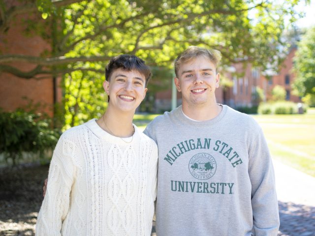 Joanna Gusis and Stephen Lewis pictured outside with a building and foliage in the background